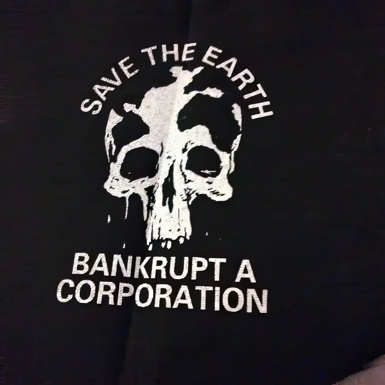 A drawing of skull with the text: SAVE THE EARTH BANKRUPT A CORPORATION