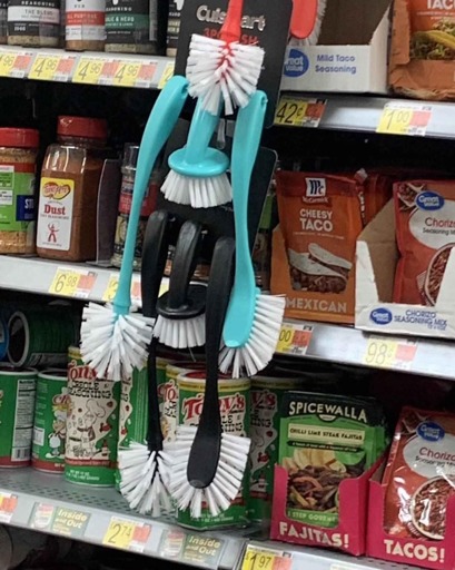 Photo of shelves on a supermarket.

There are two sets of toilet brushes hanging from one of the shelves, one in sky blue above, the other in black below.

Each set is comprised of two long brushes on the sides, and a short one in the middle.

The way the sets are arranged resembles the general shape of Hatsune Miku from Vocaloid